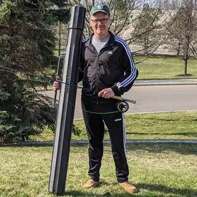 man holding fishing Rod in case on Plane