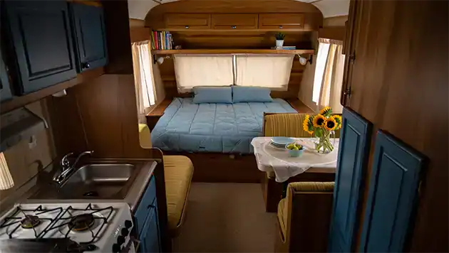 Small travel trailer bedroom, dining and kitchen